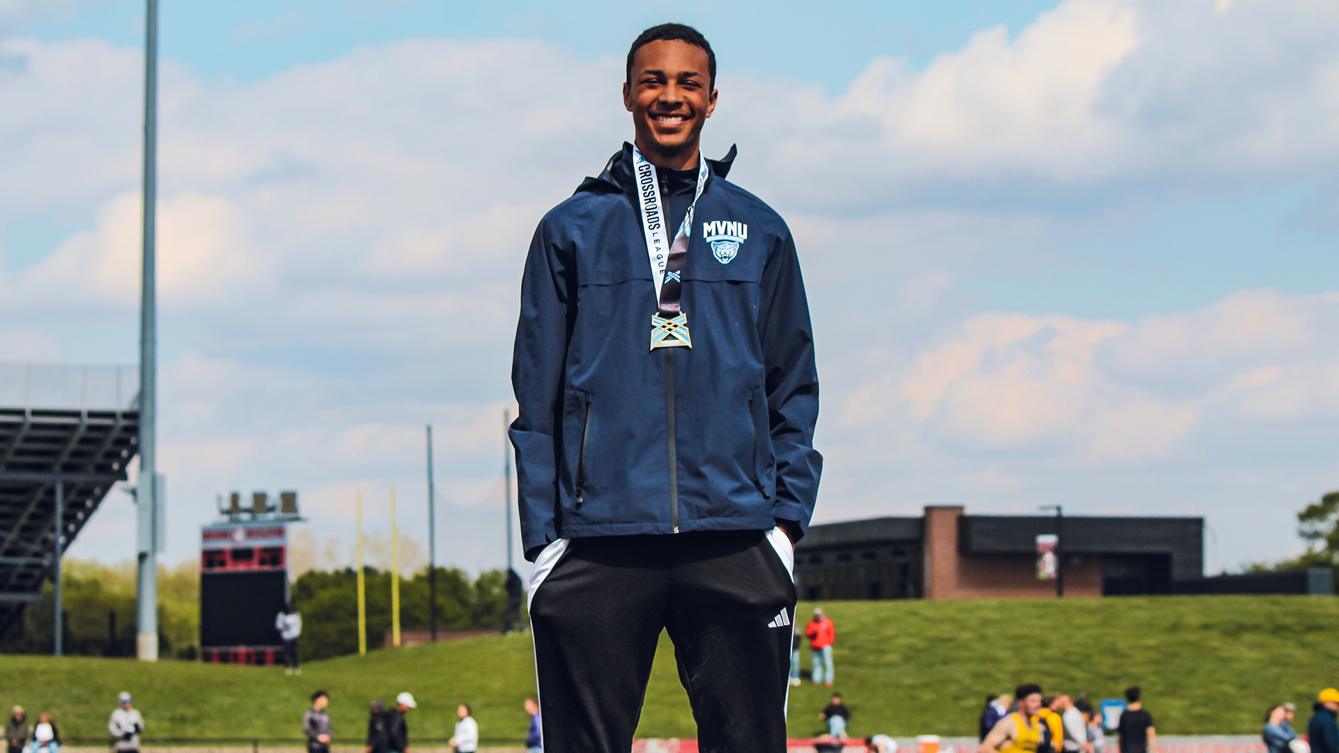 Isaac Burns stands and smiles at the camera with his first place medal